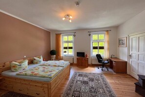 A bedroom with a wooden bed, a desk, a chair, and a television. - Fiedler holiday apartments (Heringsdorf (Seebad))