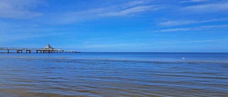 A coastal scene with a pier extending into the water.