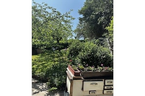 A garden with various plants and flowers, a wooden bench, and a vintage-style dresser with drawers. - Hex"nhäusla in Aufseß (Aufseß)