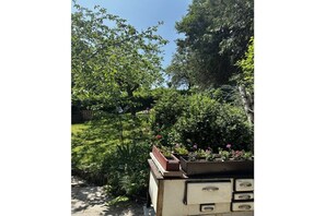 A garden with various plants and flowers, a wooden bench, and a vintage-style dresser with drawers. - Hex"nhäusla in Aufseß (Aufseß)