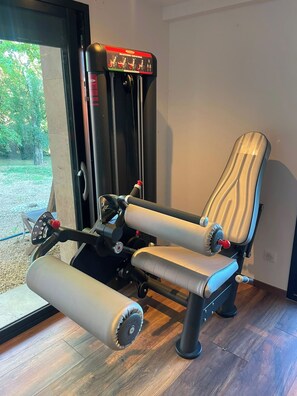 Une salle de sport équipée d'un rameur, d'une pile de poids et d'un banc de développé couché.