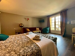 A hotel room with a large bed, a sofa, a chair, and a window with curtains. - Charming 1-bedroom house with AC in terrific Les Eyzies (les eyzies)