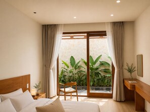 Ein Schlafzimmer mit Bett, Stuhl, Nachttisch, Spiegel und Blick auf Grünfläche.