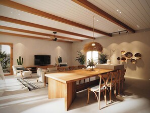 Ein modernes Wohnzimmer mit einem Holzesstisch, bequemen Sitzgelegenheiten und einem großen Fernseher.