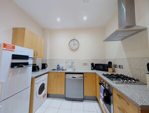 A modern kitchen with a built-in dishwasher, a gas stove, and a microwave. - City Centre 2 Bedroom Apartment Liverpool 7 MIN (Liverpool)