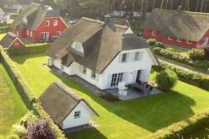 A residential area with houses featuring thatched roofs and well-maintained lawns. - Holiday home with 1 bedroom (Seebad Kölpinsee OT Stubbenfelde)