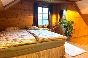A cozy room with a bed, a window, and a potted plant.