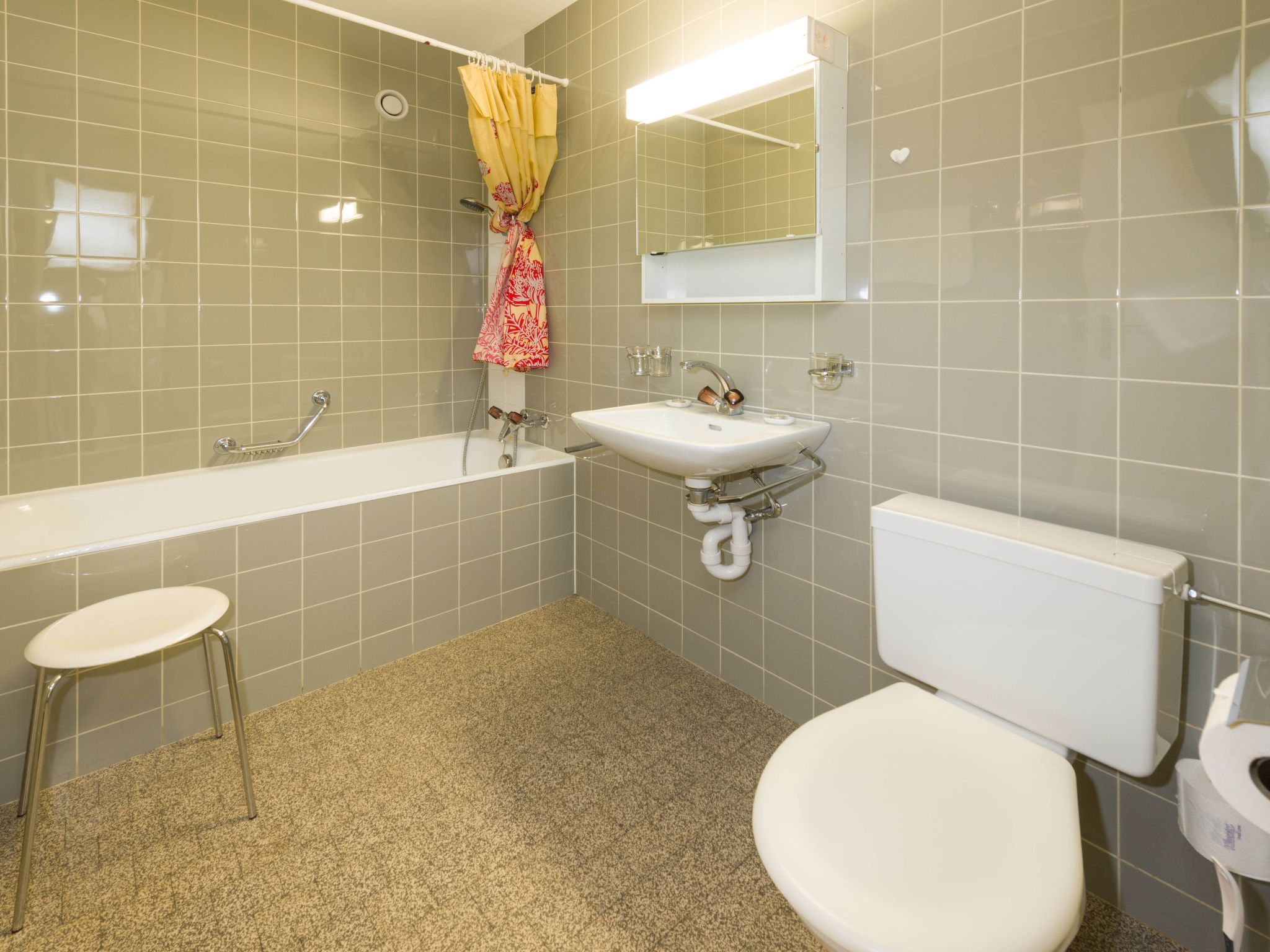Ein Badezimmer mit Badewanne, Waschbecken, Toilette und Duschvorhang.