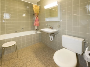 Ein Badezimmer mit Badewanne, Waschbecken, Toilette und Duschvorhang.