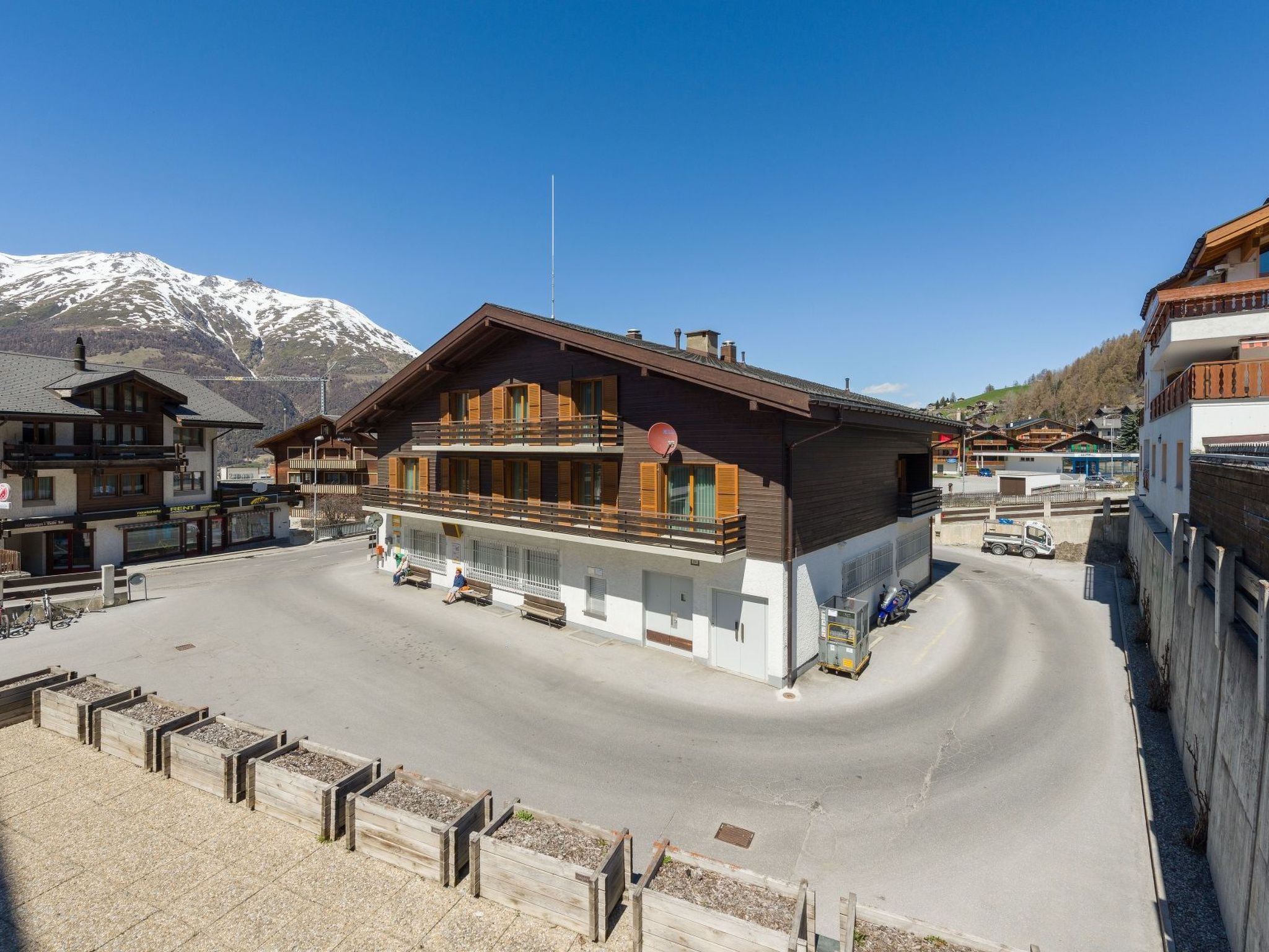 Un hôtel avec une façade en bois, un balcon et une vue sur les montagnes.