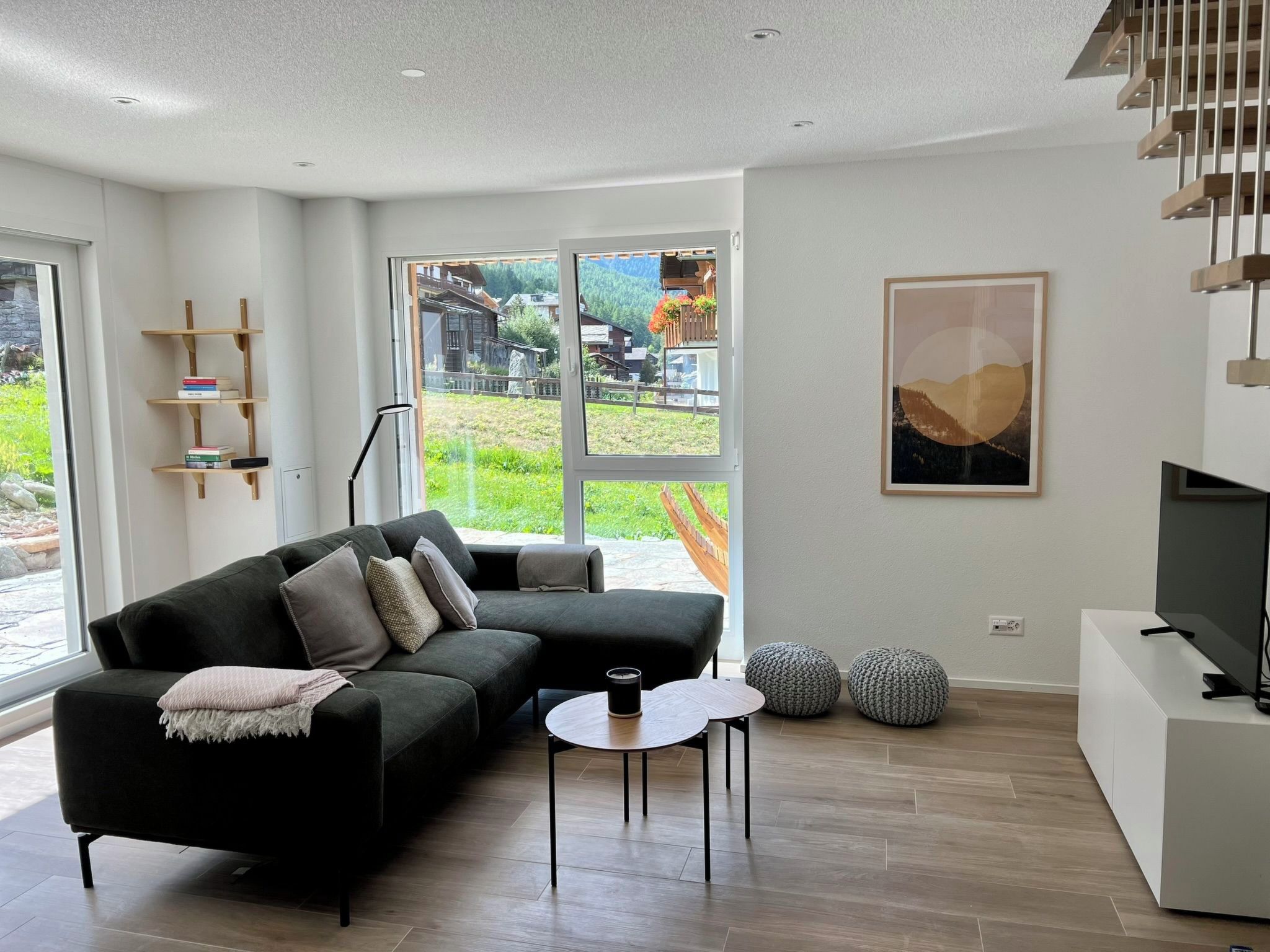 A modern living room with a sectional sofa, a coffee table, and a TV stand.