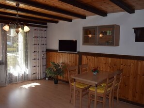 A dining area with wooden furniture, a television, and a cabinet. - Soleil, (Grächen), 1699 by Interhome (Grächen)