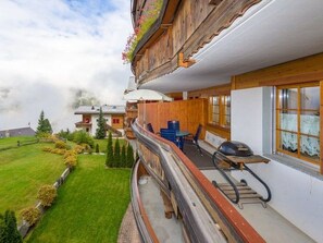 A wooden balcony with a view of a green lawn and a mountain in the background. - Beatrice, (Grächen), 1060 by Interhome (Grächen)