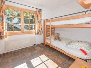 A room with a bunk bed, a window with curtains, a radiator, and a tiled floor. - Försterli Ost, (Grächen), 3003 by Interhome (Grächen)