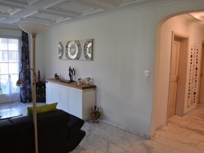 Un salon moderne avec un canapé noir, une table basse et une lampe décorative.