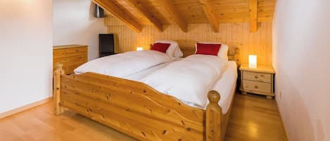 Un lit en bois dans une pièce dont le plafond et les murs sont recouverts de bois.