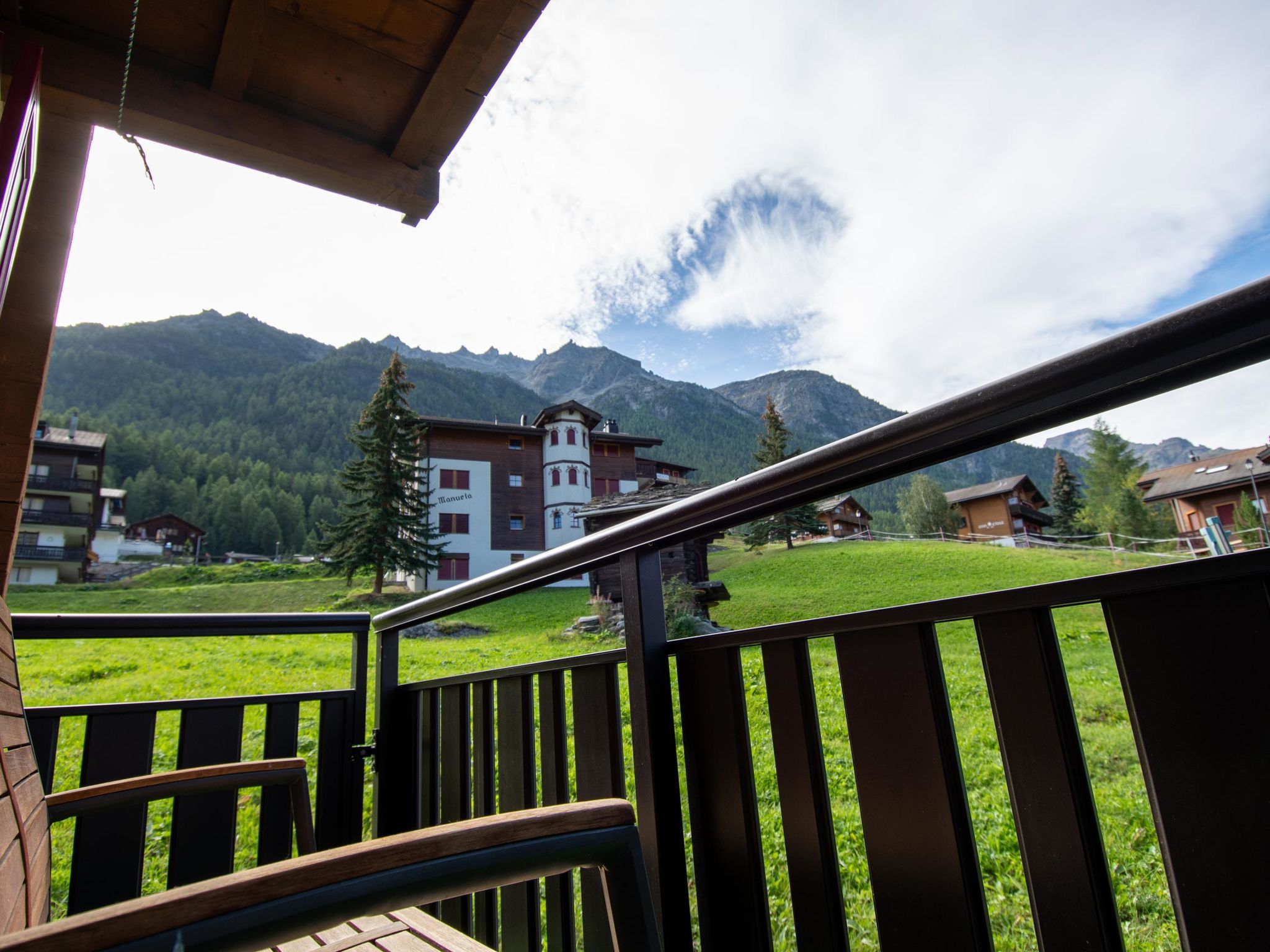Ein Balkon mit Blick auf einen Berg und ein Gebäude, an dem ein Schild 'Manuela' zu sehen ist.