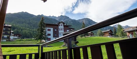 Ein Balkon mit Blick auf einen Berg und ein Gebäude, an dem ein Schild 'Manuela' zu sehen ist.