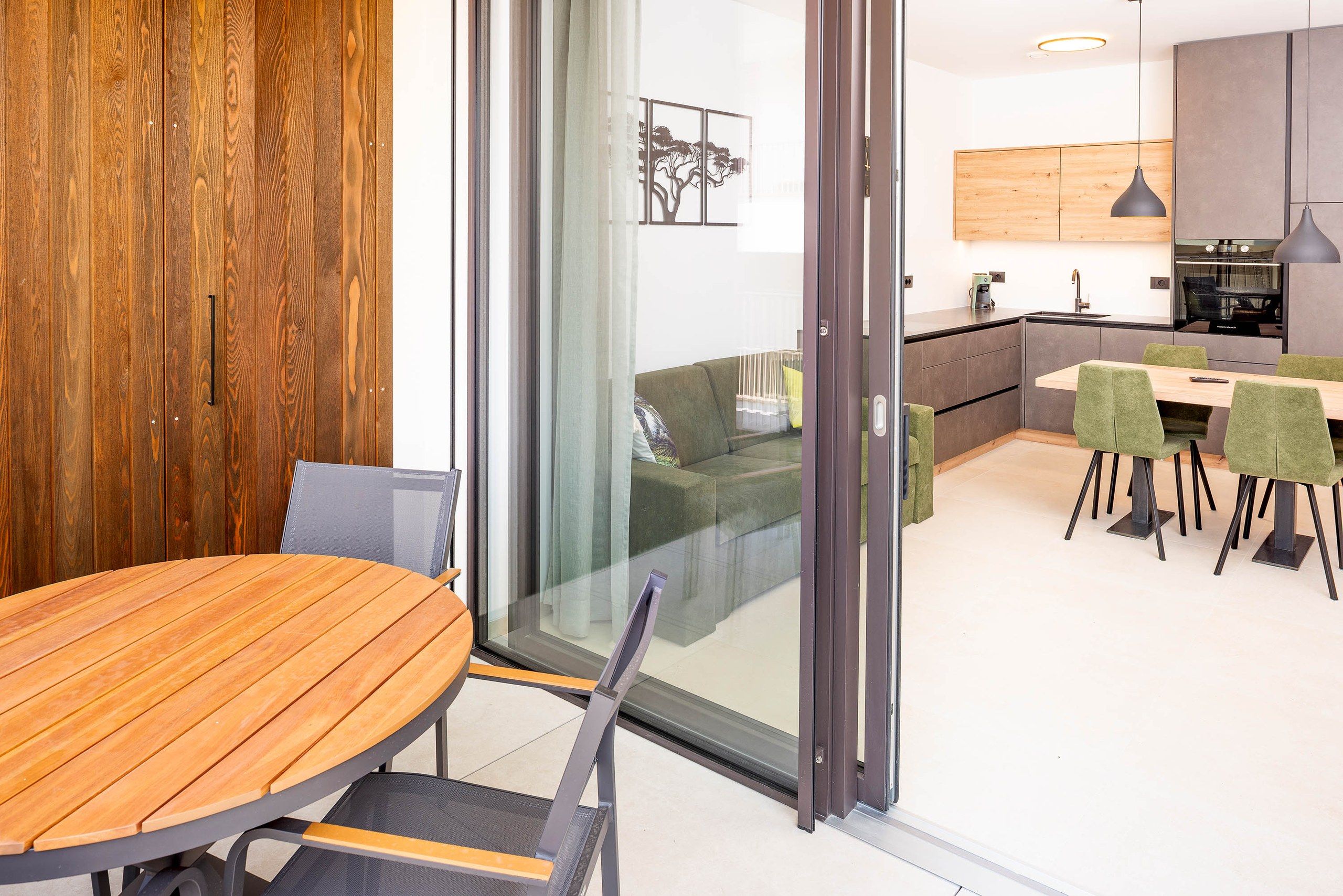 Un interior moderno con una mesa de comedor de madera, un sofá y una zona de cocina.