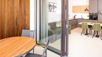 Un interior moderno con una mesa de comedor de madera, un sofá y una zona de cocina.