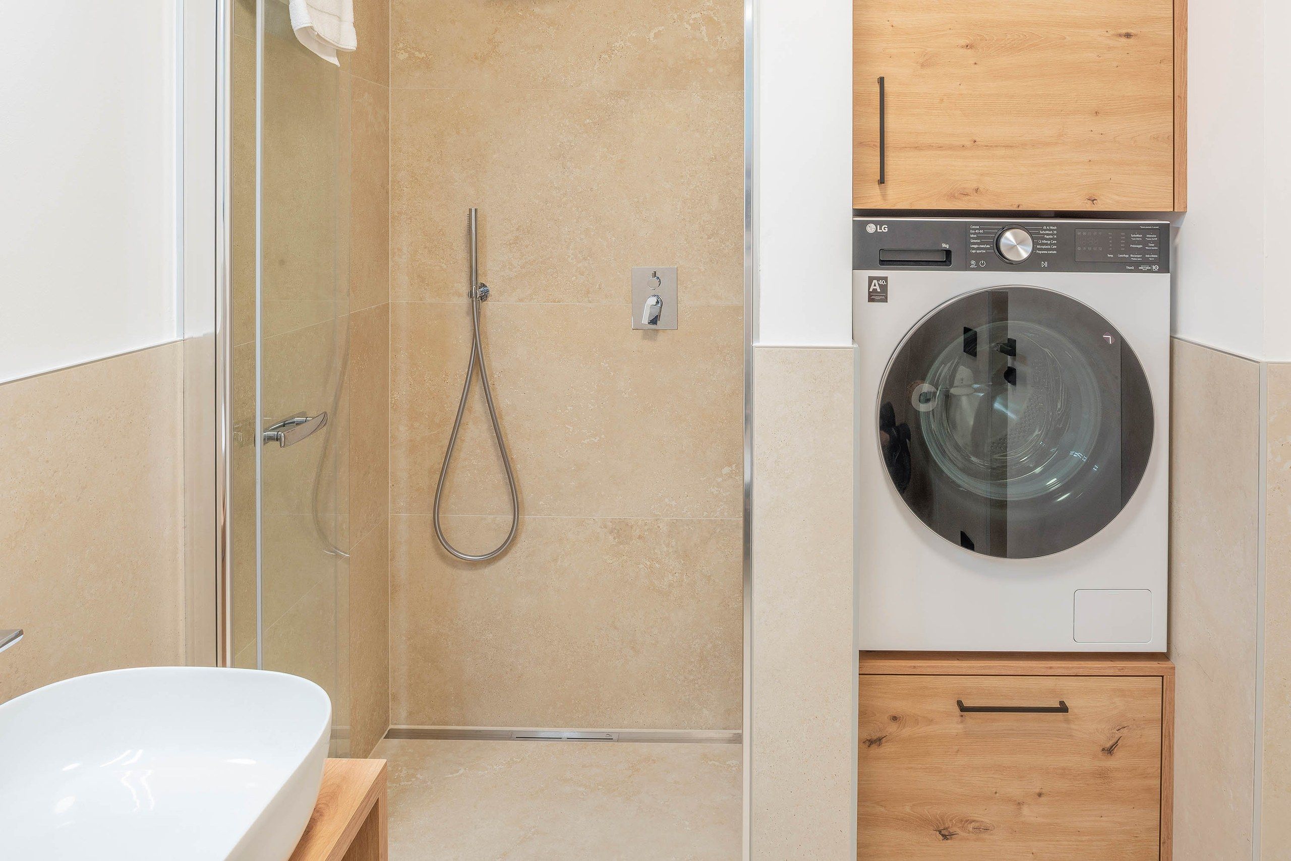 Ein Badezimmer mit Dusche, Waschmaschine und Holzschrank.