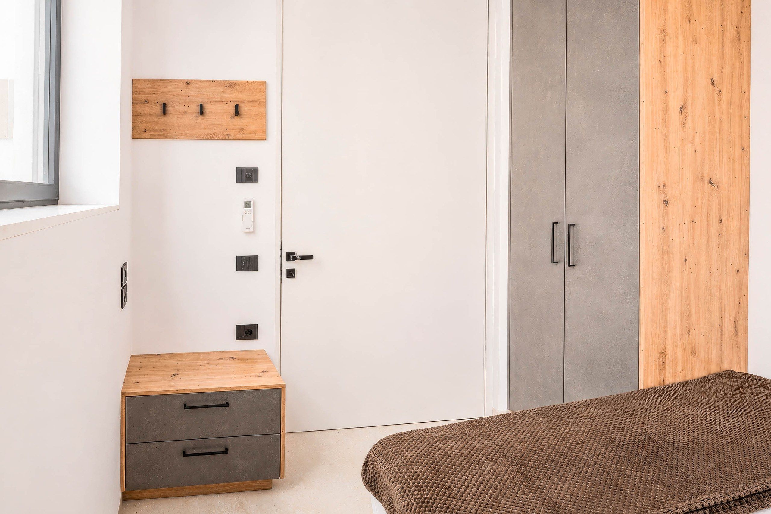 Un dormitorio con armario, mesita de noche y cama.
