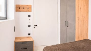 Un dormitorio con armario, mesita de noche y cama.