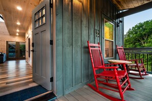 A wooden interior with a porch featuring red rocking chairs and a small table. - Smokiedoki Lodge - 3 Ensuite Bedrooms + Loft Near Parkway (Pigeon Forge)