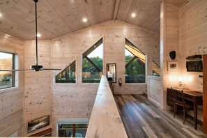A wooden cabin interior with a long dining table, large windows, and a fireplace. - Smokiedoki Lodge - 3 Ensuite Bedrooms + Loft Near Parkway (Pigeon Forge)
