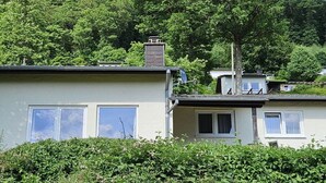 A residential building with a flat roof, a chimney, and a satellite dish.