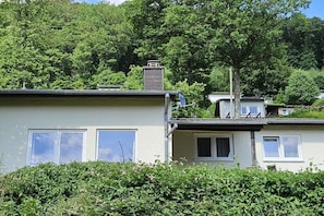 A residential building with a flat roof, a chimney, and a satellite dish.