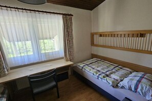 A room with a single bed, a desk, and a chair.