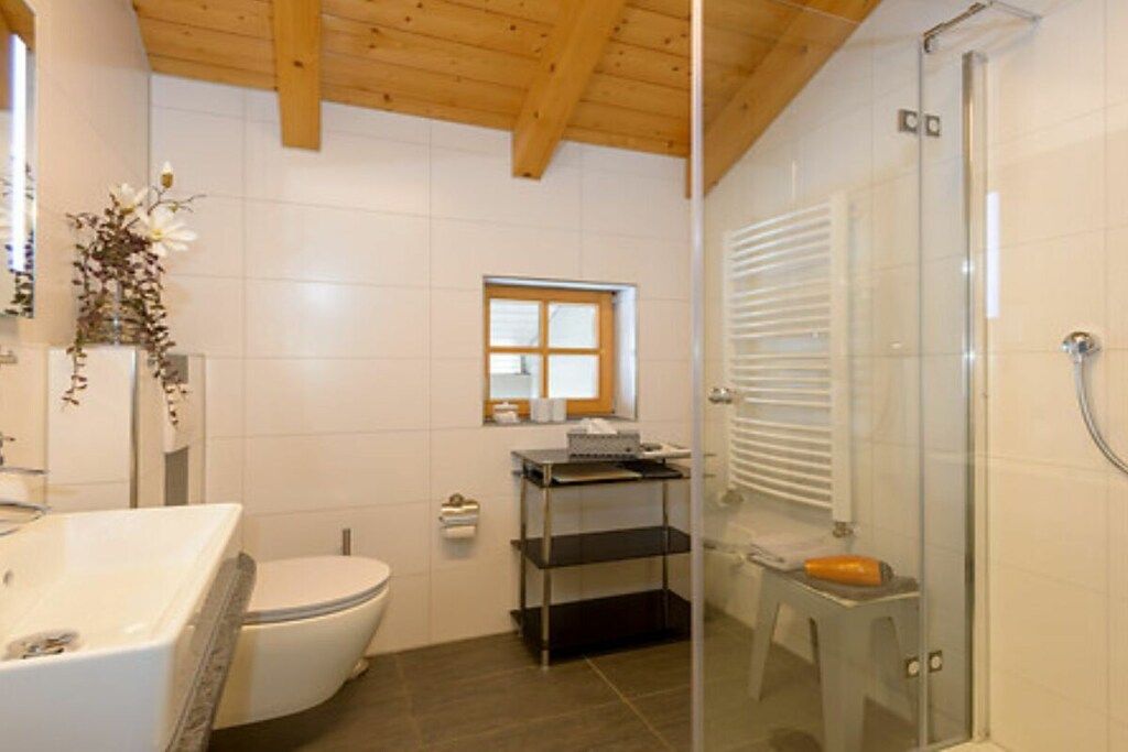Une salle de bain équipée d’une baignoire, de toilettes et d’une douche à parois de verre.