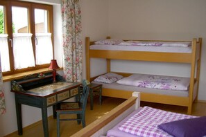 A room with a bunk bed, a desk with a chair, and a window with curtains. - Holiday apartment with 1 bedroom (Passau - Salzweg)