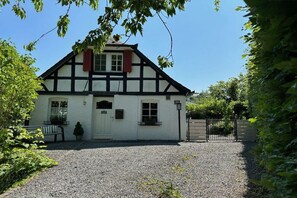 A traditional half-timbered house with a gravel driveway and a gated entrance. - Timber-framed holiday home 1764 (Eslohe)