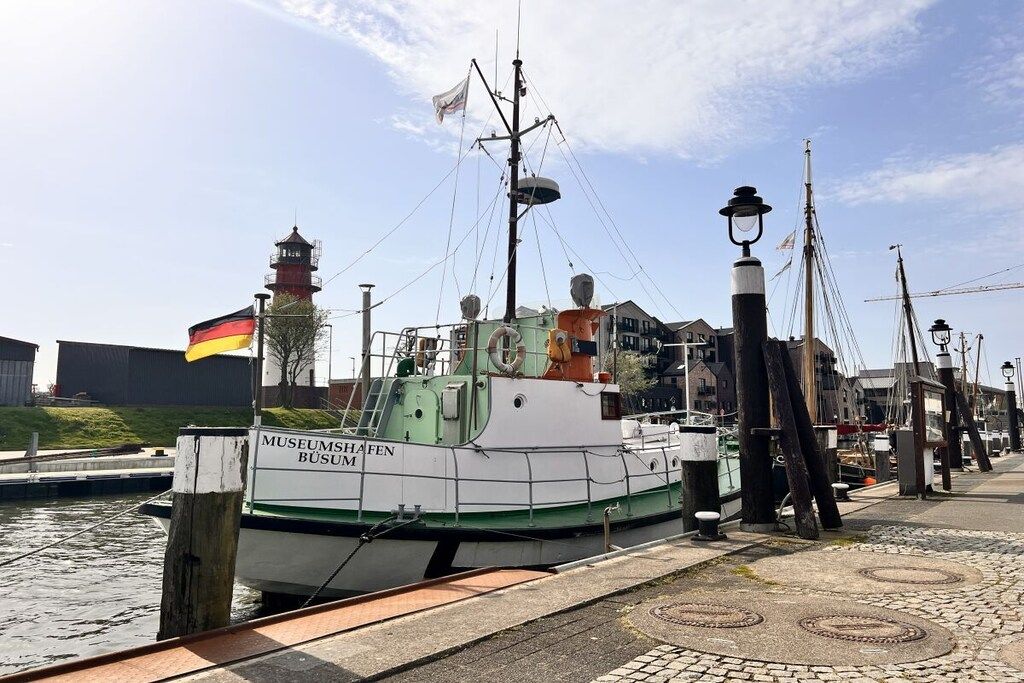 A museum boat docked at a marina with a clear sky.