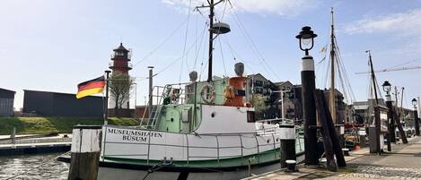 A museum boat docked at a marina with a clear sky.