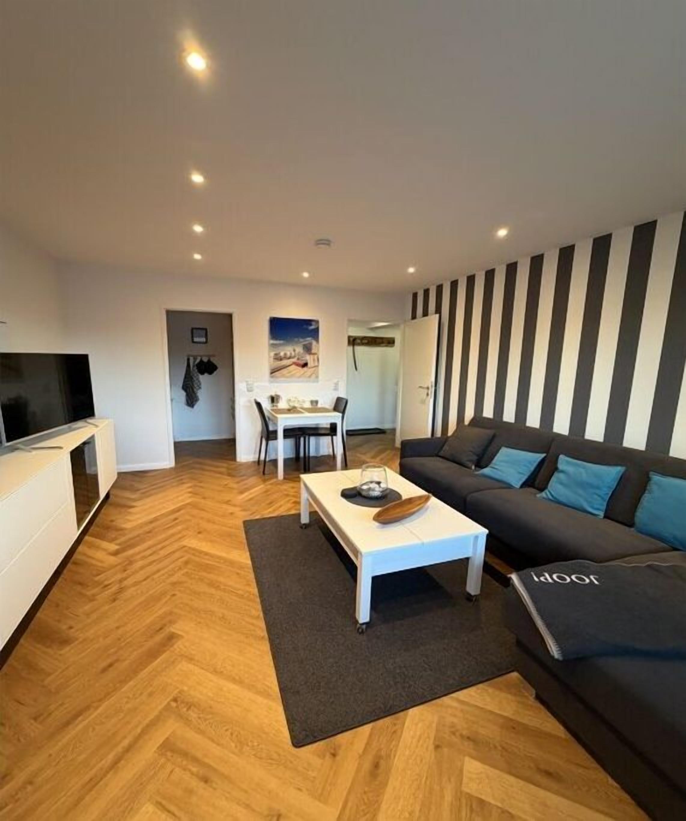 A modern living room with a sofa, a coffee table, and a TV.