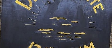 Un letrero con la inscripción 'DEICHSUITE BUSUM' en letras doradas sobre un fondo oscuro.