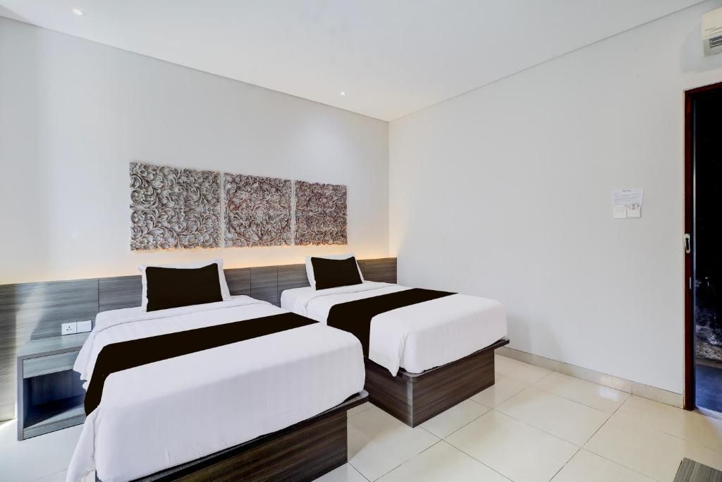 Ein Hotelzimmer mit zwei Betten, einem großen abstrakten Kunstwerk an der Wand und einem modernen Design.