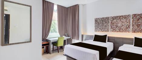 A hotel room with a bed, desk, chair, and a large mirror.