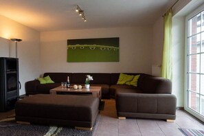 Ein modernes Wohnzimmer mit einem Ecksofa, einem Couchtisch und einem Kamin.