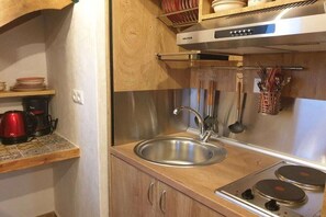 A kitchen with a stainless steel sink, a coffee maker, and a stove. - Studio Komos Gallery (Pitsidia)