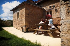A stone building with a wooden bench outside. - Chateau le Colombier "Le Poirier" (Brévands)