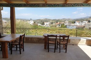 Zona d'estar a l'aire lliure coberta amb vista a una vila i turons.