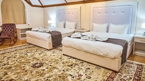 A hotel room with two beds, a large arched window, and a patterned carpet. - Queens Hotel (Tashkent)