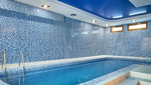 A swimming pool with a tiled wall and steps leading into it. - Queens Hotel (Tashkent)