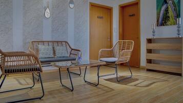 Une pièce comprenant un canapé, un fauteuil, une petite table et un meuble en bois.