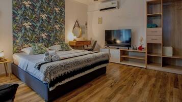 Une chambre moderne avec un lit, une télévision, un bureau et une armoire.