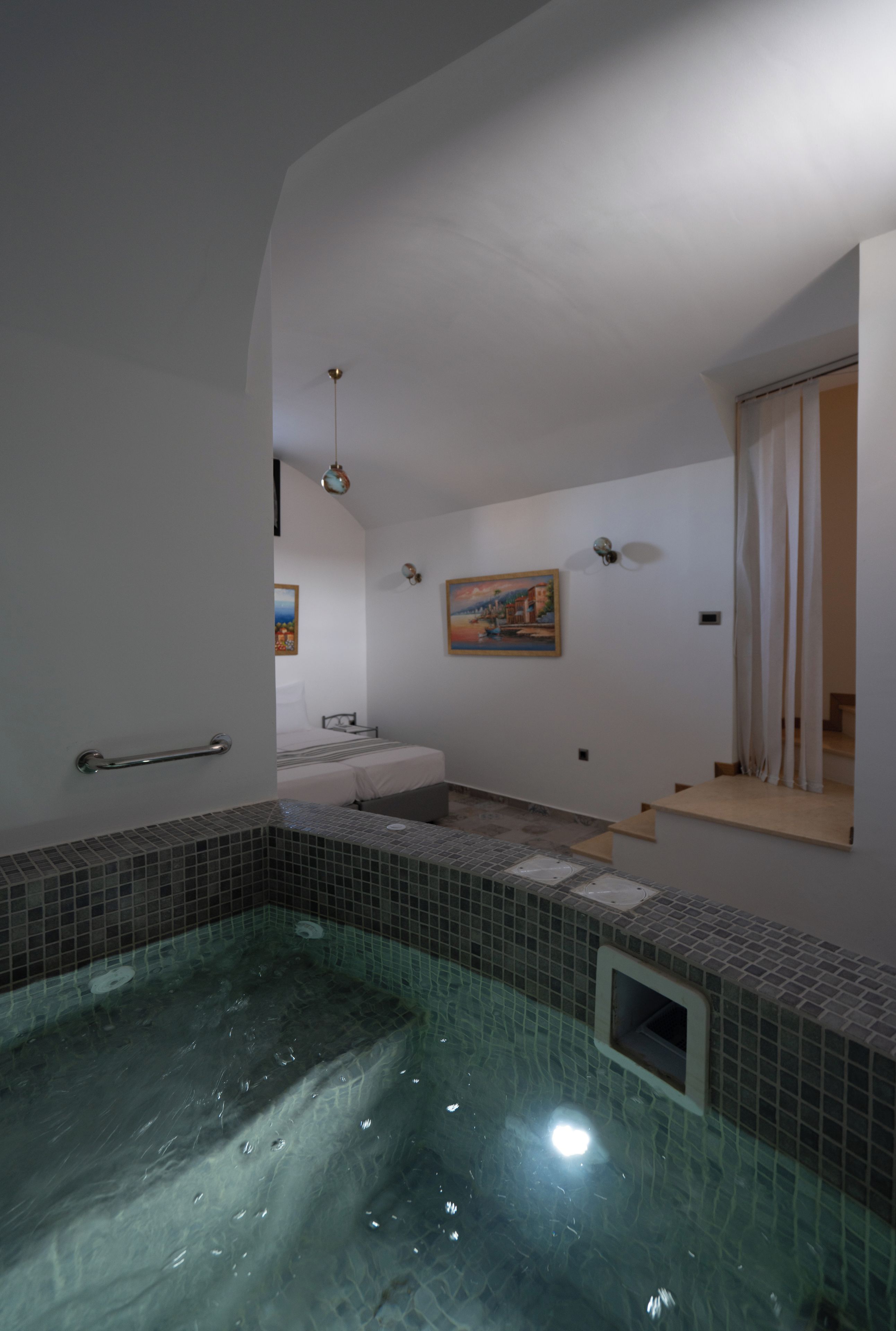 A room with a bathtub, a sink, and a painting on the wall.